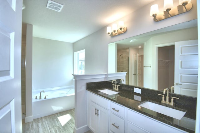 bathroom featuring vanity, hardwood / wood-style floors, shower with separate bathtub, and a textured ceiling