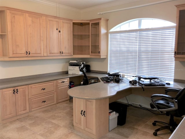 home office with light tile flooring, built in desk, and ornamental molding