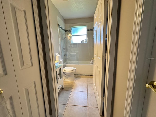 full bathroom featuring toilet, a textured ceiling, vanity, tiled shower / bath, and tile flooring