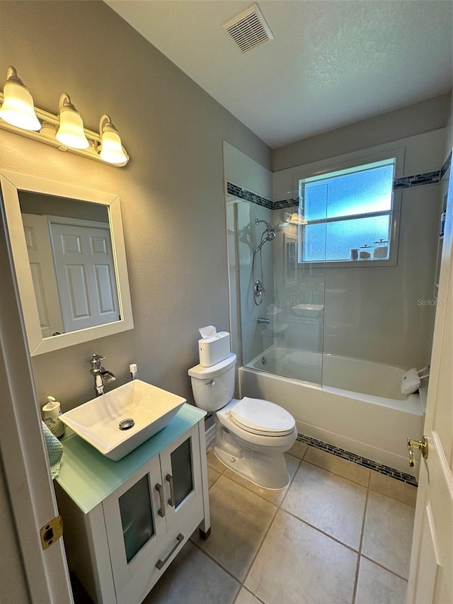 full bathroom with large vanity, toilet, tile floors, and tiled shower / bath