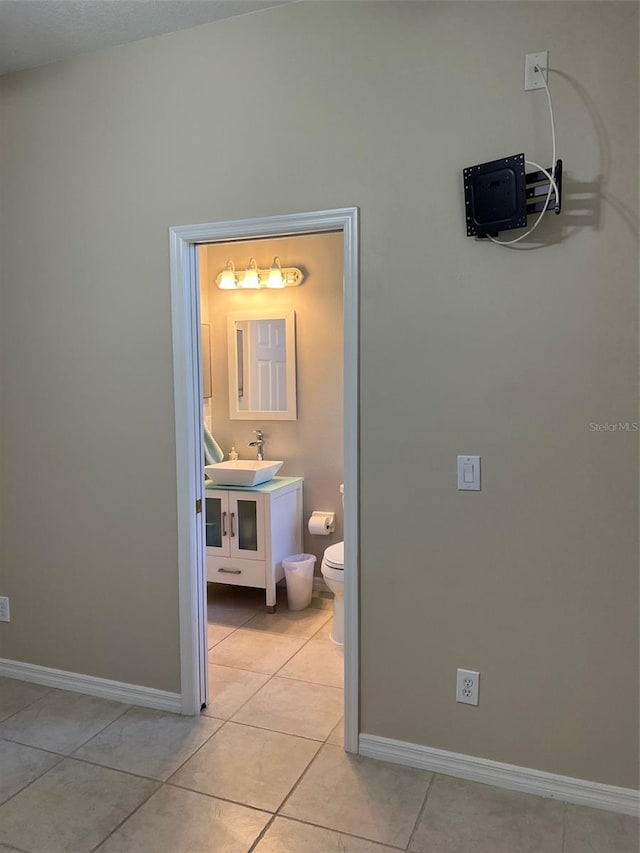 hall with light tile flooring and sink