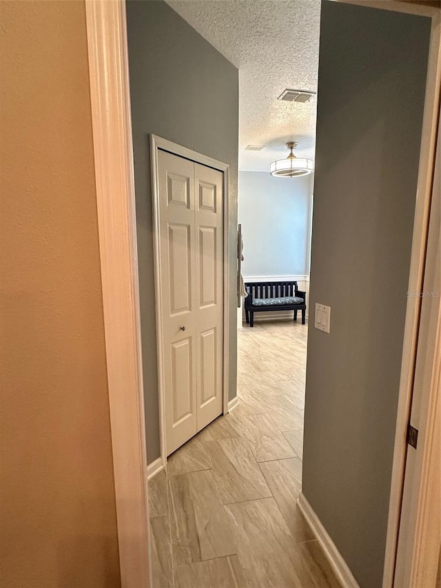 corridor with a textured ceiling