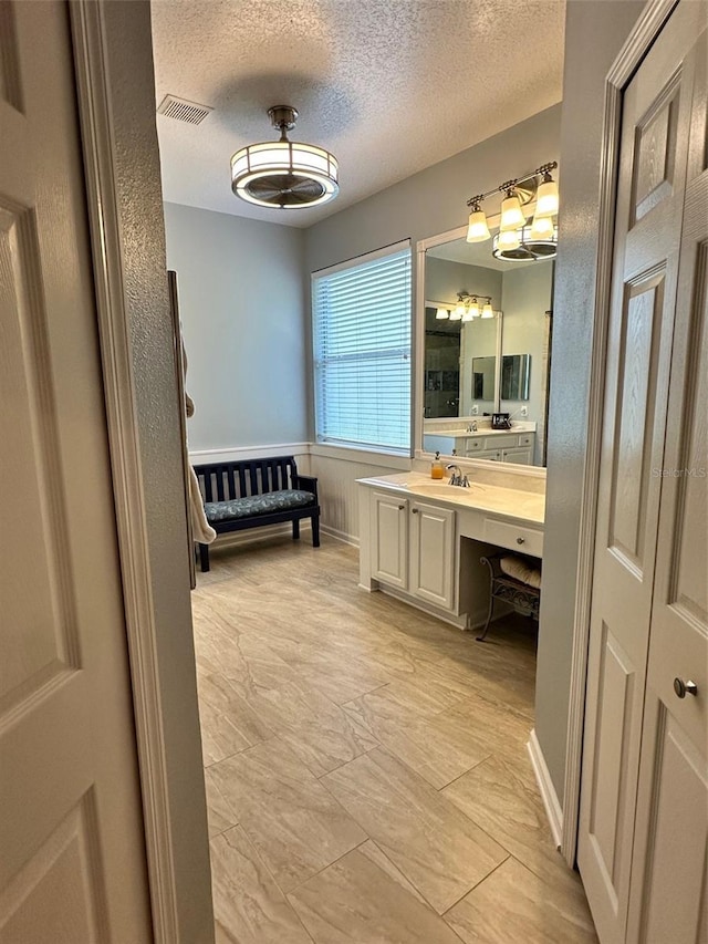 bathroom with a textured ceiling, vanity, and tile flooring