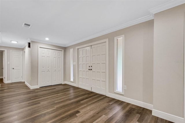 foyer with dark hardwood / wood-style floors and crown molding