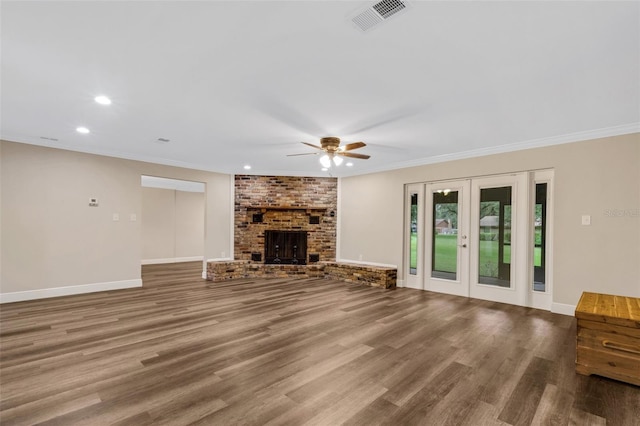 unfurnished living room featuring hardwood / wood-style floors, ornamental molding, and a fireplace