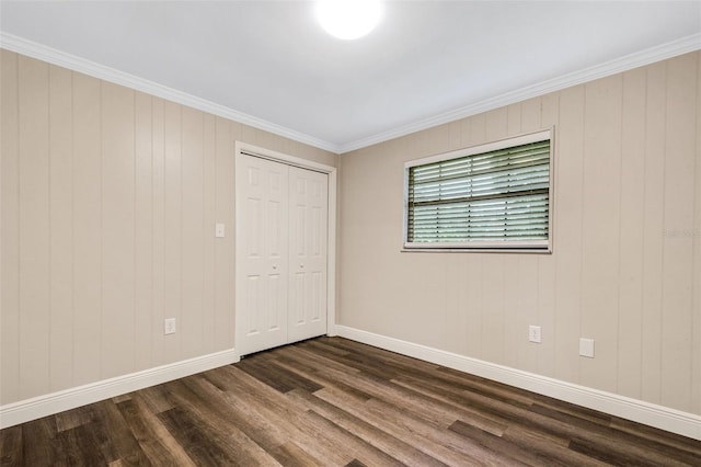 spare room with dark hardwood / wood-style flooring and ornamental molding