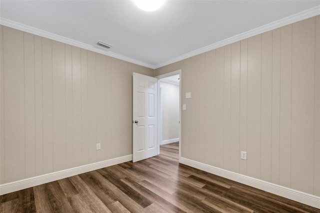 empty room with dark hardwood / wood-style flooring and ornamental molding