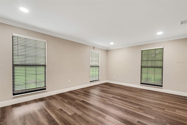 spare room featuring ornamental molding and dark hardwood / wood-style flooring