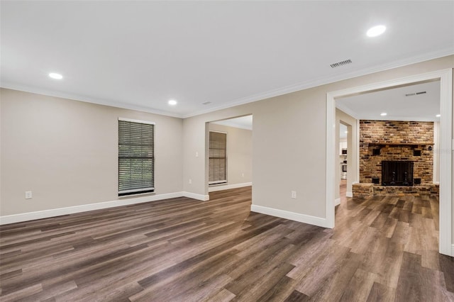 spare room with ornamental molding, dark hardwood / wood-style floors, and a fireplace