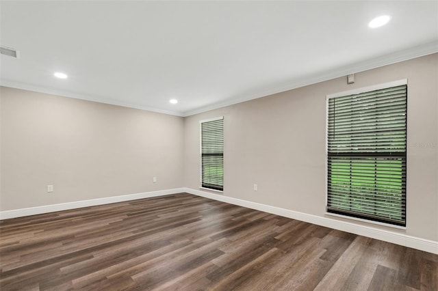 spare room featuring dark hardwood / wood-style floors and ornamental molding