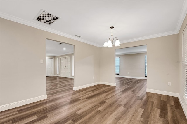 unfurnished room with crown molding, dark hardwood / wood-style floors, and an inviting chandelier