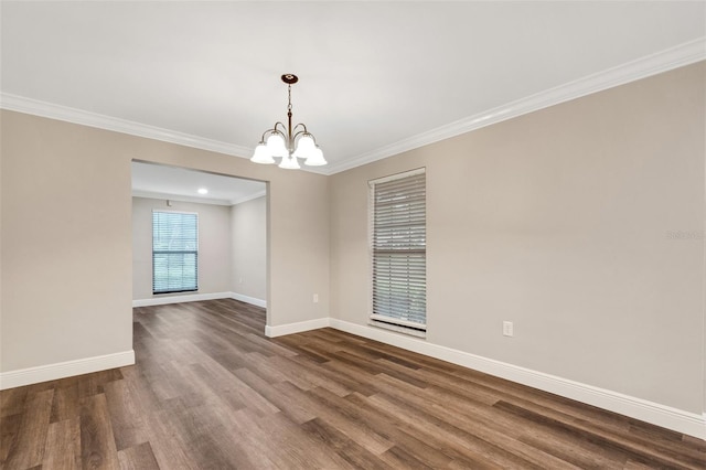 spare room featuring ornamental molding, a notable chandelier, and dark hardwood / wood-style floors