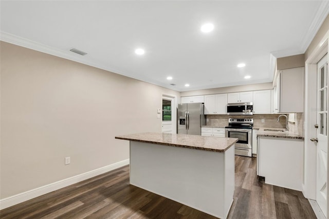 kitchen with a center island, light stone counters, dark wood-type flooring, and stainless steel appliances