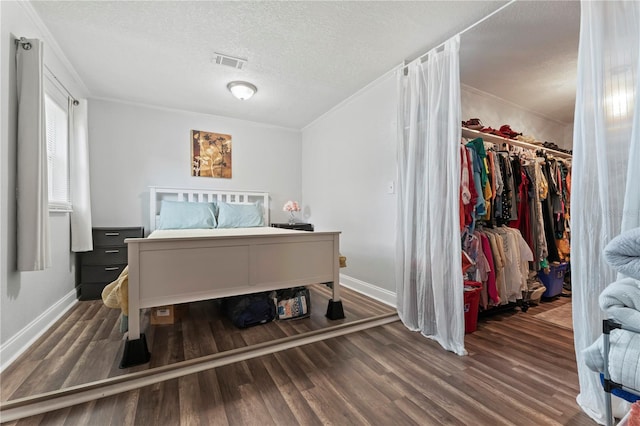 3016 Reiter Dr, Auburndale, FL 33823 - bedroom with ornamental molding, dark hardwood / wood-style flooring, a closet, and a textured ceiling