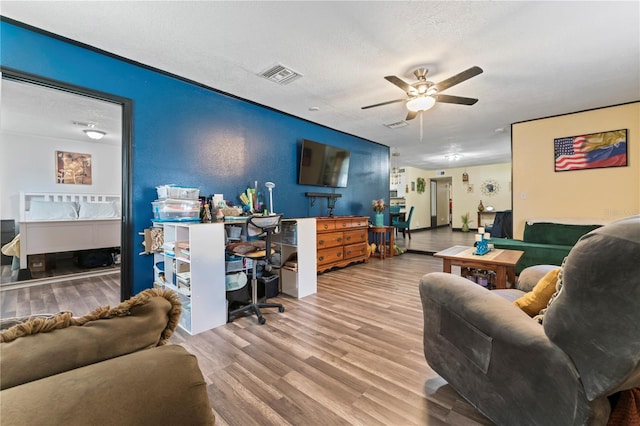 3016 Reiter Dr, Auburndale, FL 33823 - living room featuring a textured ceiling, ceiling fan, and light wood-type flooring