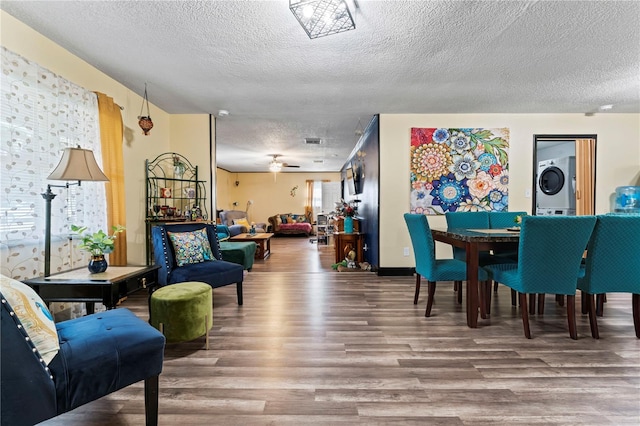 3016 Reiter Dr, Auburndale, FL 33823 - dining area featuring a textured ceiling, ceiling fan, hardwood / wood-style floors, and stacked washer and clothes dryer