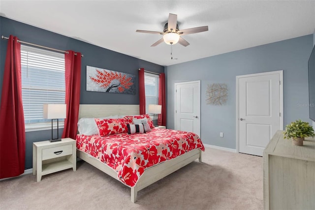 carpeted bedroom with ceiling fan and multiple windows