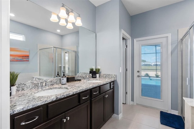 bathroom featuring vanity, an enclosed shower, a notable chandelier, and tile patterned flooring