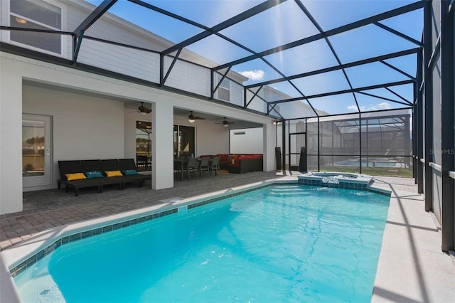 view of pool with an in ground hot tub, a patio, glass enclosure, and ceiling fan