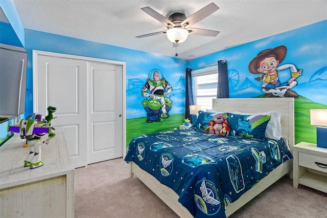 carpeted bedroom with a closet, a textured ceiling, and ceiling fan