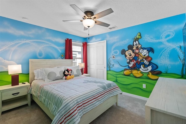 carpeted bedroom with a closet, ceiling fan, and a textured ceiling