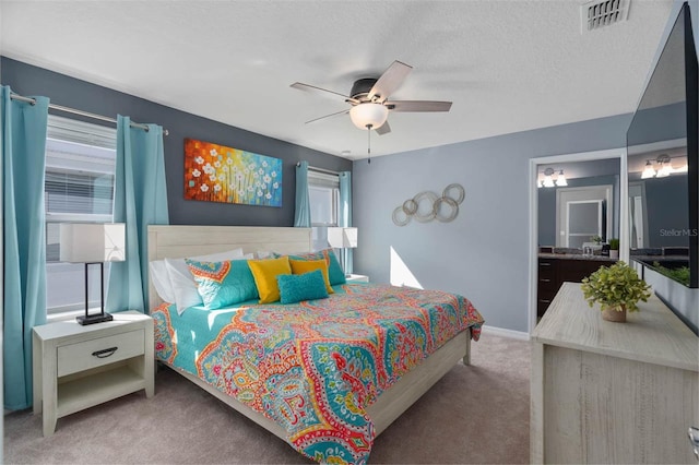 bedroom featuring connected bathroom, carpet flooring, multiple windows, and ceiling fan