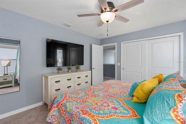 bedroom featuring a closet, light colored carpet, and ceiling fan