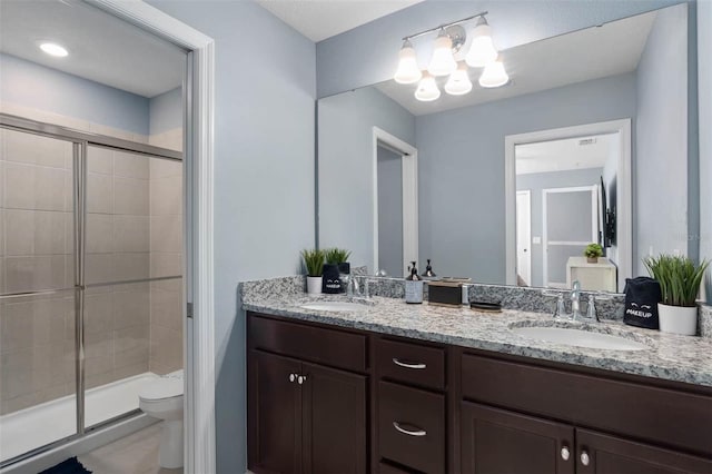 bathroom featuring vanity, toilet, a chandelier, and a shower with door