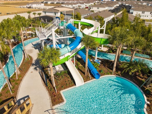 view of pool with a water slide and a playground