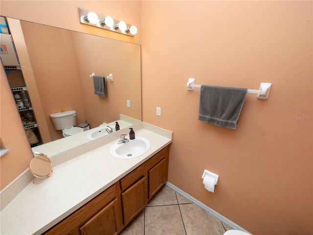 bathroom featuring toilet, baseboards, vanity, and tile patterned floors