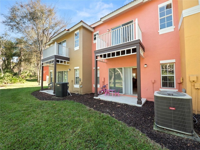 rear view of property with central AC, a yard, a patio, and stucco siding