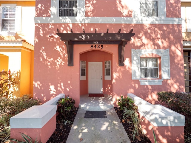 entrance to property with stucco siding