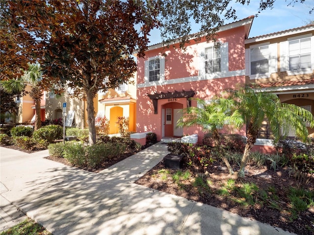 view of front of house with a tiled roof and stucco siding