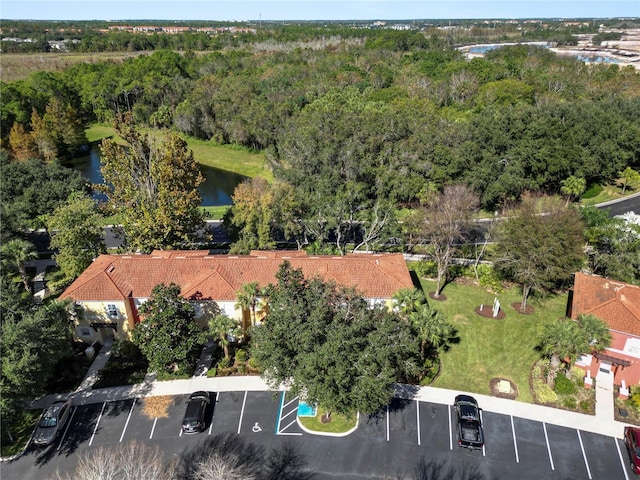 drone / aerial view featuring a water view and a wooded view