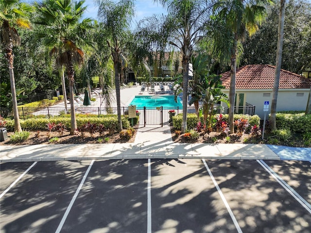 view of property's community featuring a patio, a swimming pool, and fence