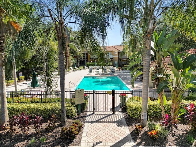 community pool featuring a gate, fence, and a patio