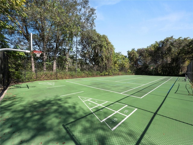 view of home's community with shuffleboard and fence