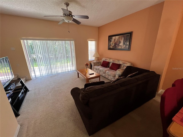 carpeted living room featuring a textured ceiling and a ceiling fan