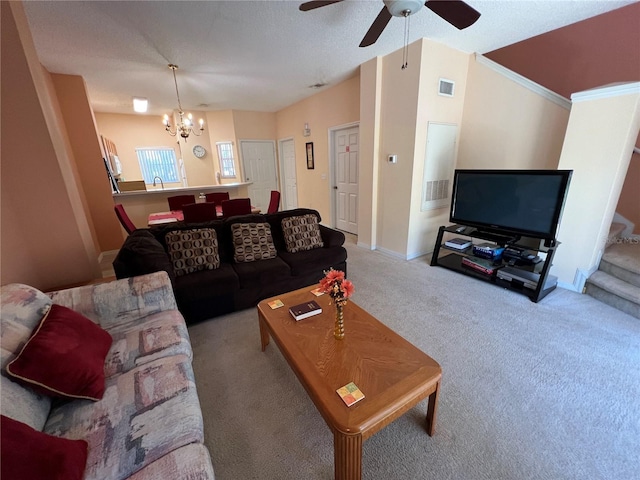 living area featuring stairs, visible vents, carpet flooring, baseboards, and ceiling fan with notable chandelier