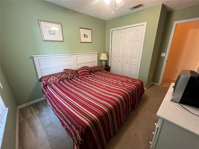 carpeted bedroom featuring baseboards, a closet, visible vents, and a textured ceiling