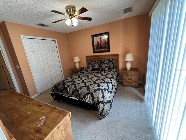 bedroom with a closet, a textured ceiling, visible vents, and carpet flooring