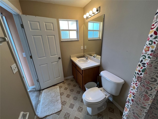 full bath with toilet, baseboards, and vanity