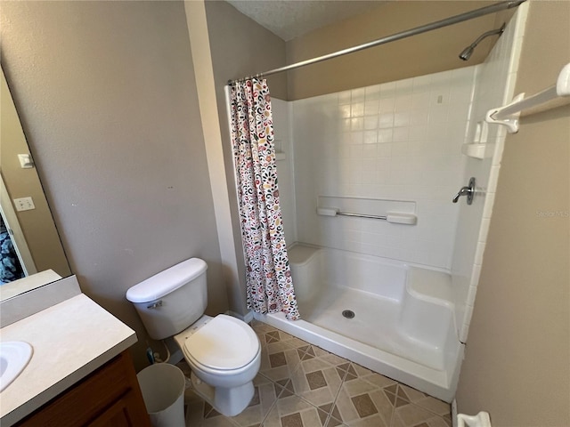 bathroom with toilet, a stall shower, and vanity