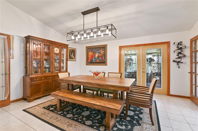 dining space with vaulted ceiling, light tile patterned floors, a textured ceiling, and french doors