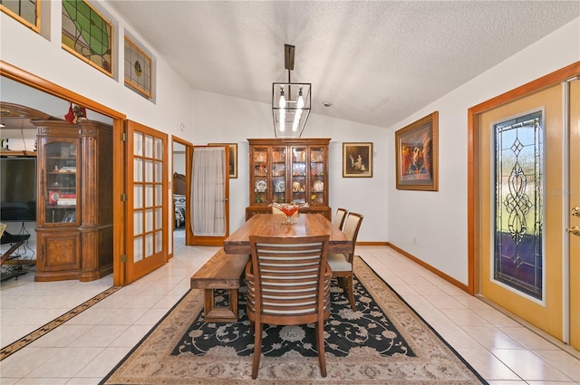 tiled dining space with a chandelier, french doors, a textured ceiling, and lofted ceiling