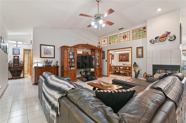 tiled living room featuring ceiling fan, a fireplace, and high vaulted ceiling