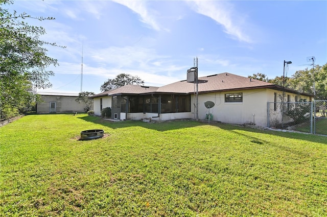 rear view of house with a yard and a sunroom