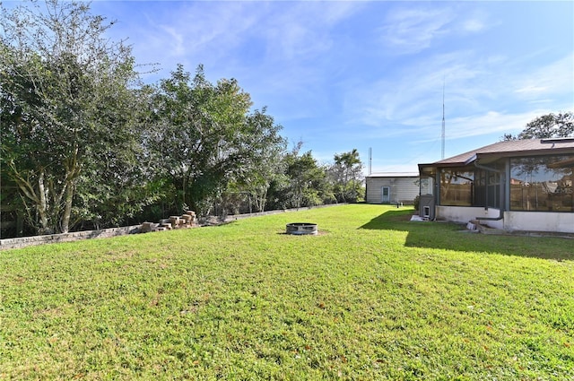 view of yard with a sunroom and an outdoor fire pit