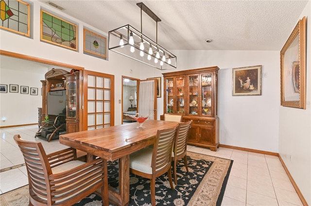 dining room featuring light tile patterned floors, a textured ceiling, high vaulted ceiling, and french doors