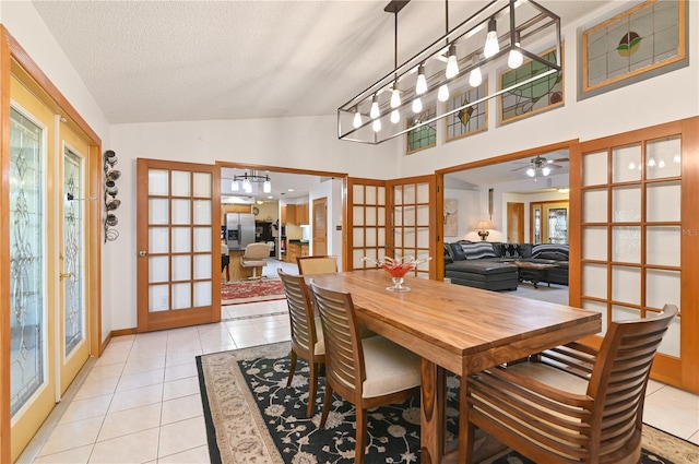 tiled dining area featuring ceiling fan, lofted ceiling, a textured ceiling, and french doors